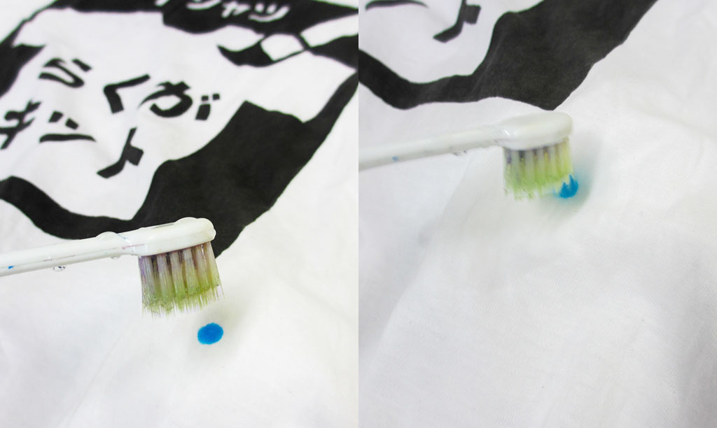 はねた絵の具を消すために水を含む歯ブラシでこする様子
